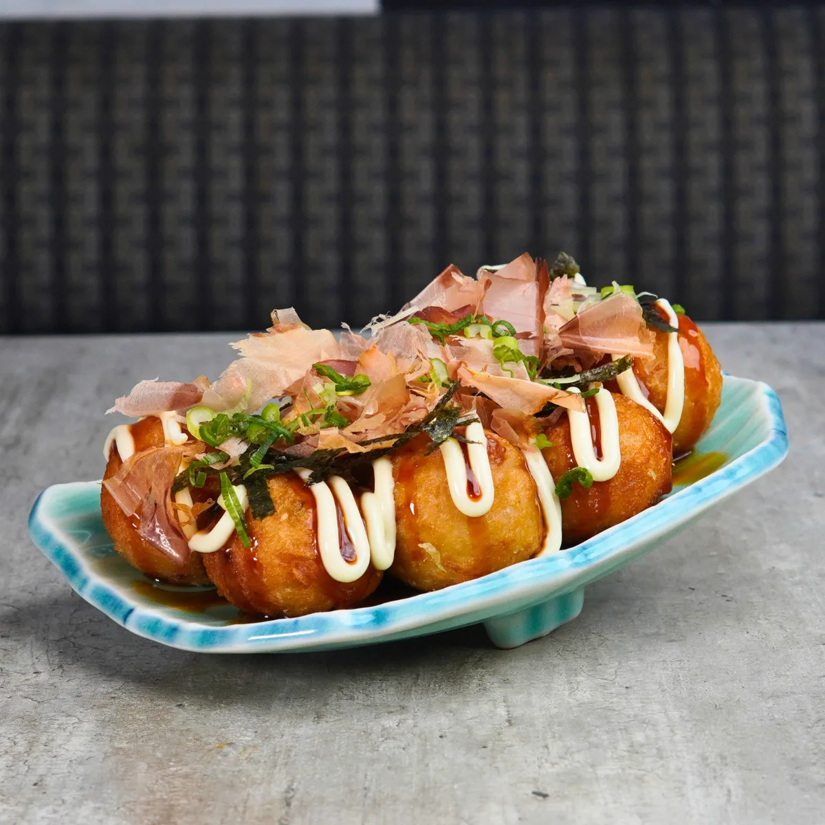 Takoyaki topped with smoked tuna flakes, white mayo and teriyaki